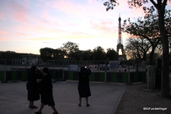 Nuns taking photos Eiffel Tower at dusk